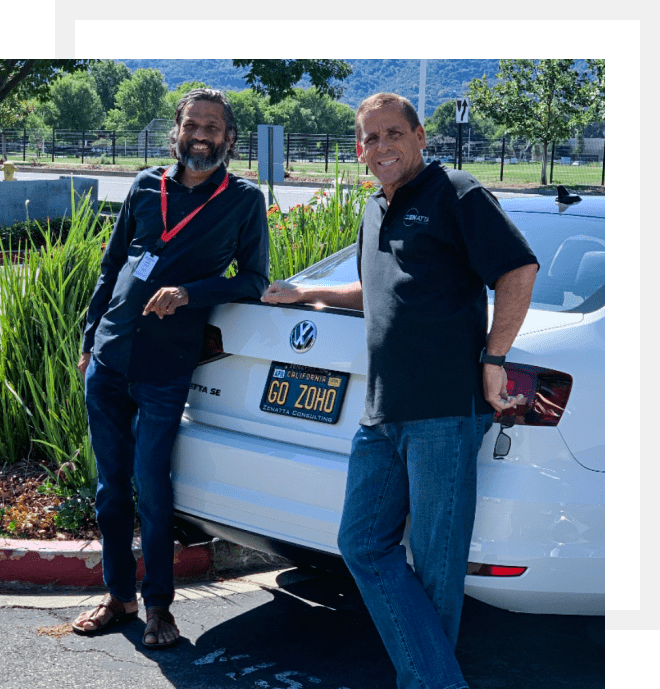 Brett Martin of Zenatta Consulting and Shridar Vembu, CEO of Zoho, posing by a car